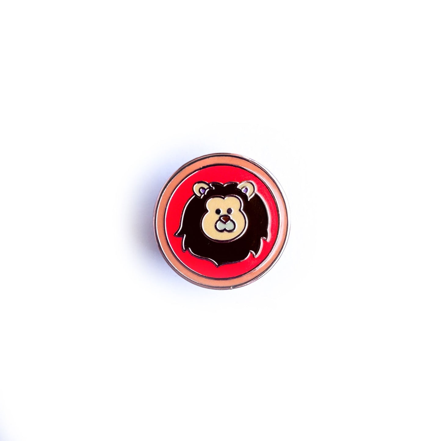 A circular enamel pin with a cute lion illustration in it to represent the Leo zodiac sign.