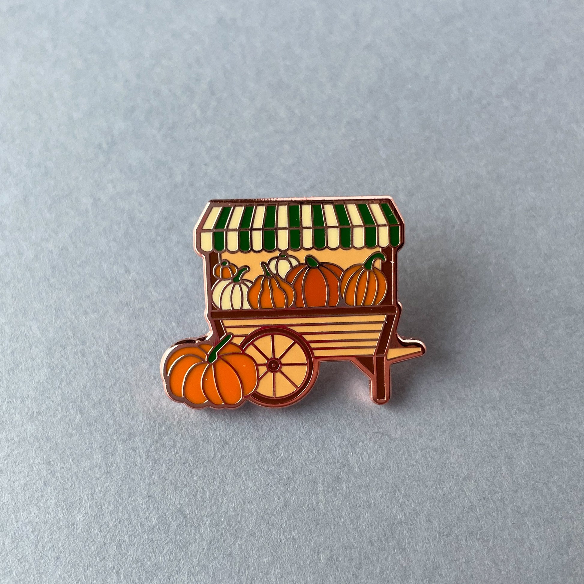 A pumpkin cart pin on a grey background